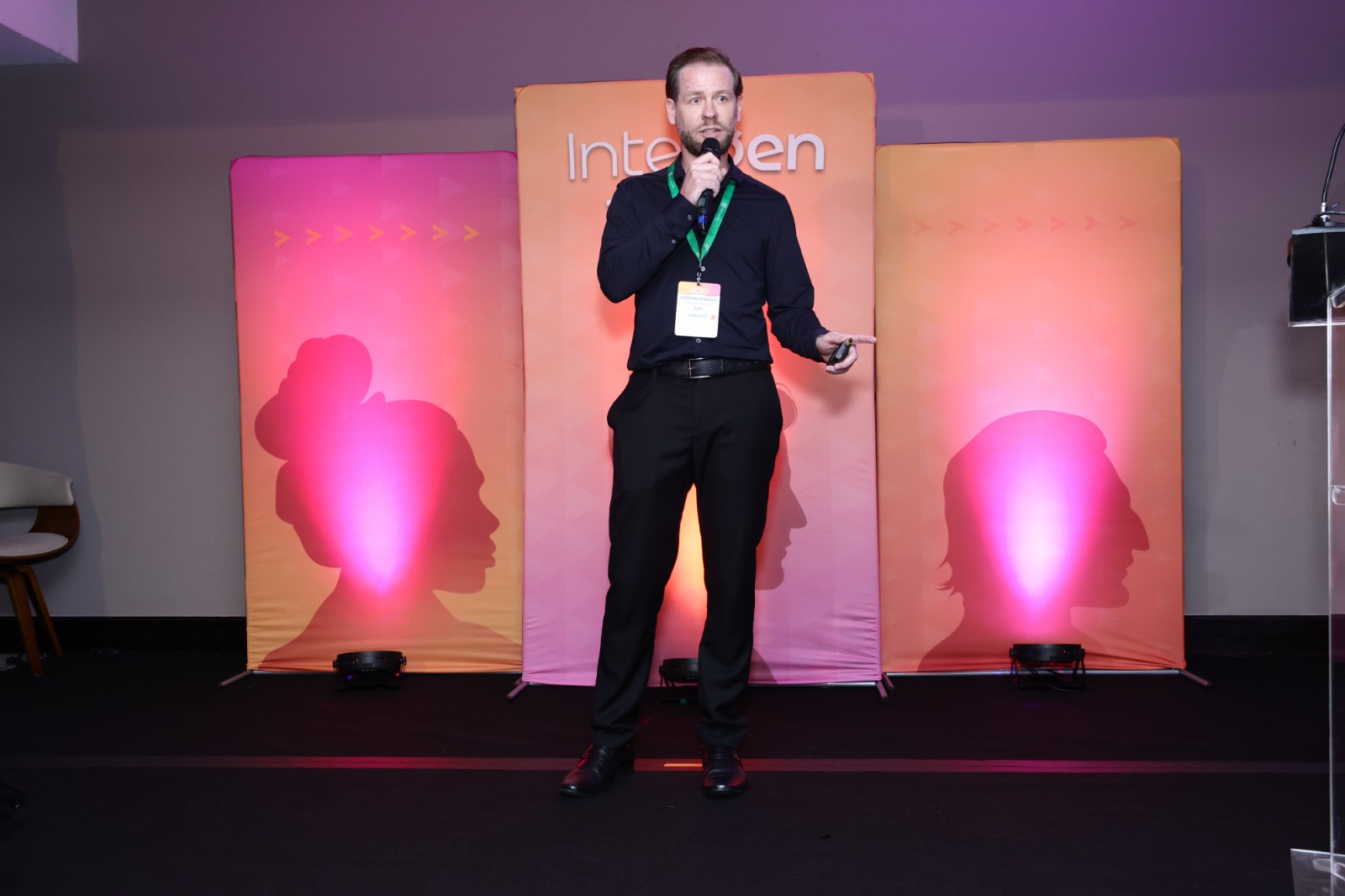 Everton Dzikovicz em pé no palco, de microfone, na palestra do Intergen Tech.